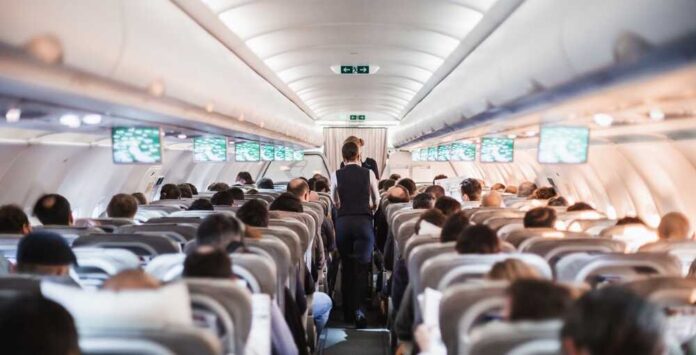 Interior,Of,Airplane,With,Passengers,On,Seats,And,Stewardess,In
