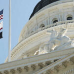 Federal Rescue for California’s Unemployment Chaos Flags and statue outside government building dome