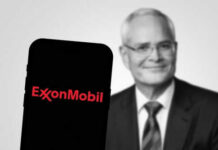 ExxonMobil logo on phone, blurred man in background.