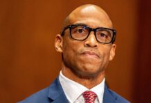 Man in a suit with glasses displaying a serious expression