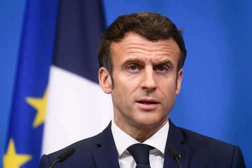 Man speaking at podium in front of flags