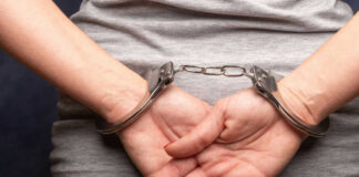 Persons hands in handcuffs behind their back