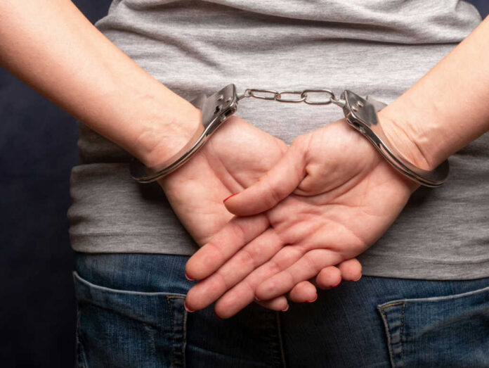 Persons hands in handcuffs behind their back