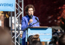 Senate Showdown: Democrats Push Biden-Era Policies A woman in a blue suit speaking at a podium during a political rally