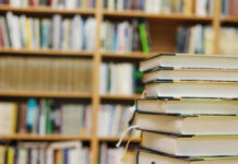 Stack of books in a library with shelves in the background