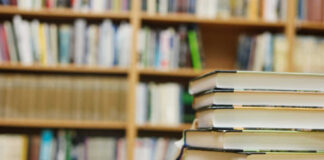 Stack of books in a library with shelves in the background