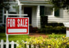 A 'For Sale' sign in front of a house