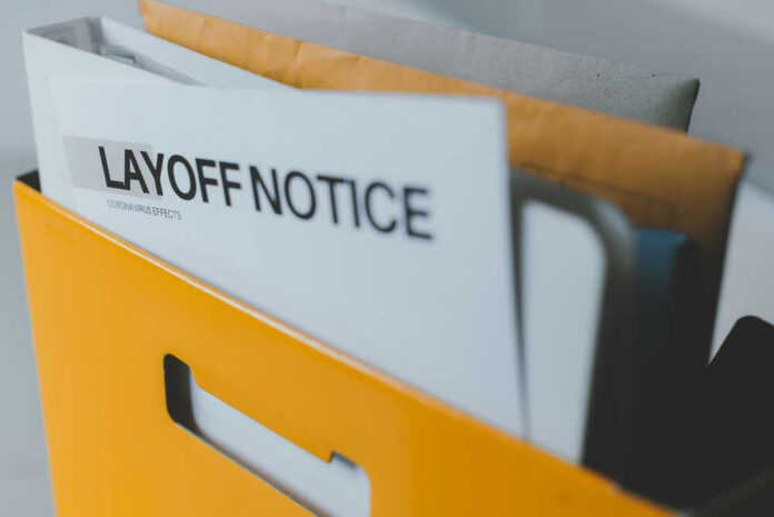 A yellow folder containing a layoff notice and other documents