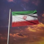 Iranian flag waving against a sunset sky
