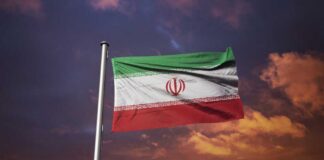 Iranian flag waving against a sunset sky