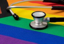 A stethoscope resting on a rainbow flag background