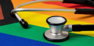 A stethoscope resting on a rainbow flag background
