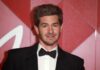 Andrew Garfield smiling at a red carpet event in formal attire