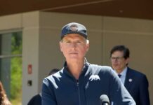 Politician speaking at a press conference outdoors