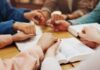Controversial Bill C-9: Is Preaching Now a Crime? Group of hands holding each other over an open Bible