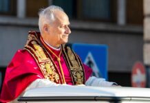 A religious leader in ceremonial attire smiling during a public appearance