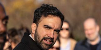 A man speaking passionately to a group of people outdoors