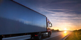 A truck driving on a highway during sunset