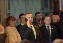 Man in a suit making a phone call at a crowded event