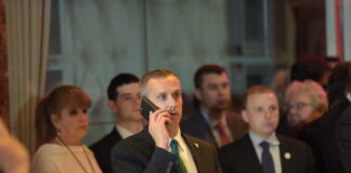 Man in a suit making a phone call at a crowded event