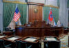 Interior view of a courtroom with flags and wooden furnishings