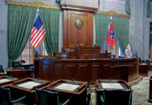 Interior view of a courtroom with flags and wooden furnishings