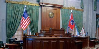 Interior view of a courtroom with flags and wooden furnishings
