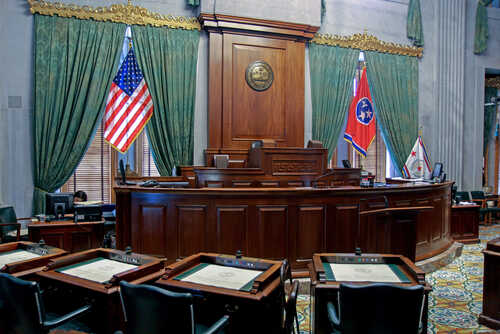 Interior view of a courtroom with flags and wooden furnishings
