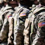 Soldiers in camouflage with American flag patches standing
