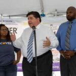 Pritzker’s REDISTRICTING Gambit Sparks Illinois Tension Three people speaking at a promotional event.