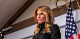 Woman speaking at podium with American flag background