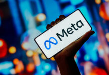 Hand holding smartphone displaying Meta logo
