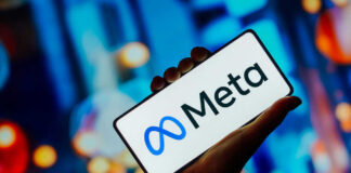 Hand holding smartphone displaying Meta logo
