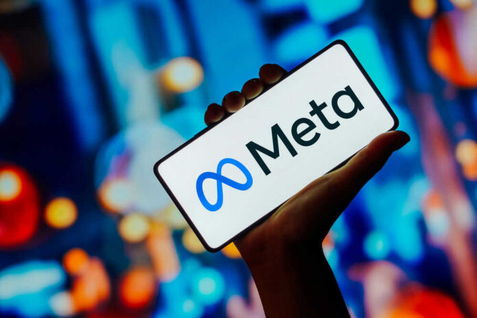 meta-683040568jpg Hand holding smartphone displaying Meta logo