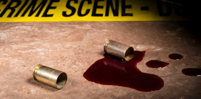 Bullet casings and blood on a surface near a crime scene tape