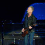 Fleetwood Mac Legend’s Stalker Finally Nabbed A guitarist performing on stage with amplifiers in the background
