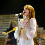 A female singer passionately performing on stage with a microphone