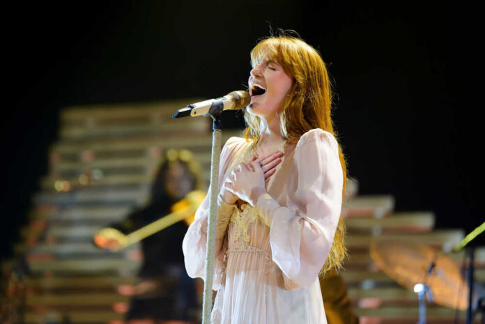 A female singer passionately performing on stage with a microphone