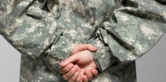 Person in military uniform with hands clasped behind their back