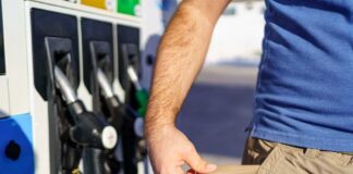 Person showing empty pockets at a gas station