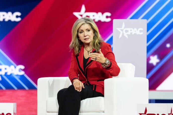 A woman in a red blazer speaking at a conference