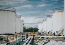 Industrial oil storage tanks with pipelines under a cloudy sky