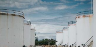 Industrial oil storage tanks with pipelines under a cloudy sky