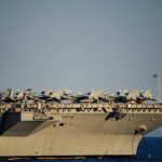 Close-up of an aircraft carrier with fighter jets on deck