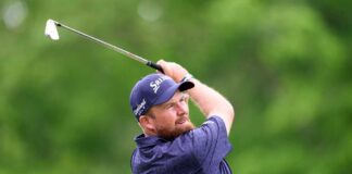 Golfer executing a swing on a lush green course