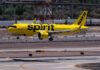 A yellow Spirit Airlines airplane landing on an airport runway