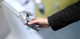 A human hand reaching out to touch a robotic hand