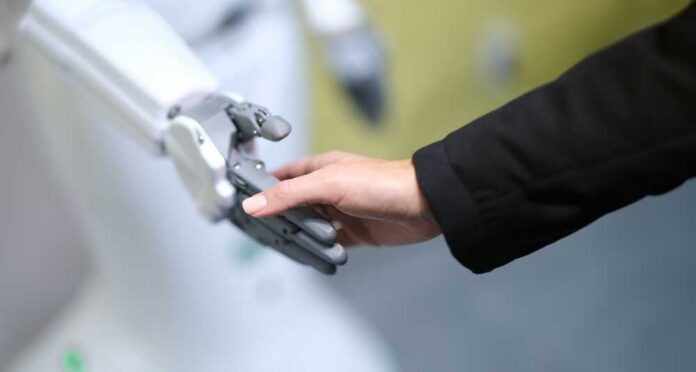 A human hand reaching out to touch a robotic hand