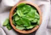 Cancer-Busting Nutrient Found in Your Veggies! Fresh spinach leaves in a wooden bowl on a linen surface
