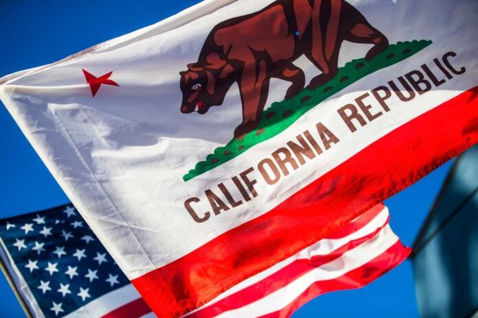 California Republic flag waving alongside the American flag against a blue sky
